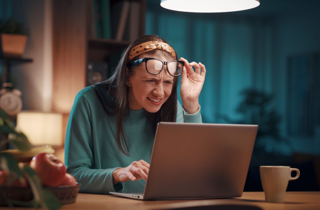 a person squinting at their computer screen wondering if their nearsightedness got worse with age