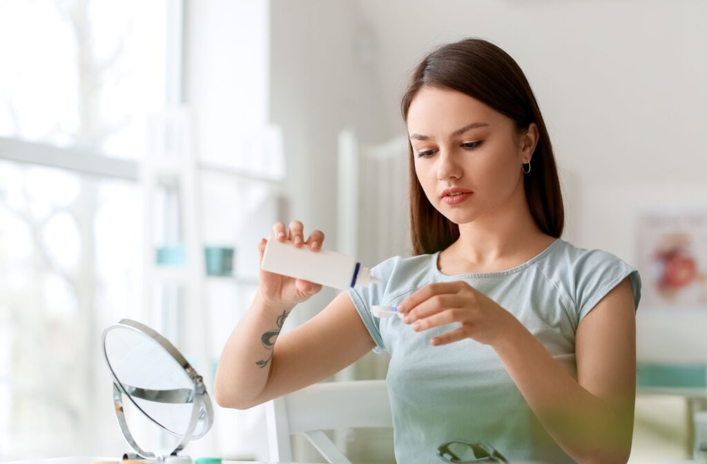 A person pouring contact lens solution into a clean contact case to properly care for her contact lenses.